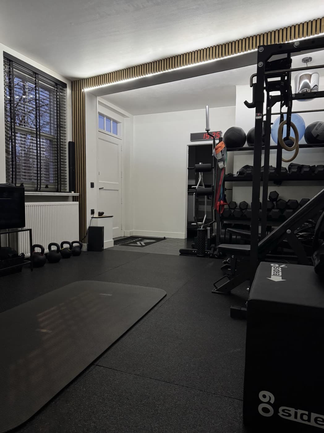 Volledig uitgeruste private trainingsruimte met kettlebells, dumbbells, rack en ringen